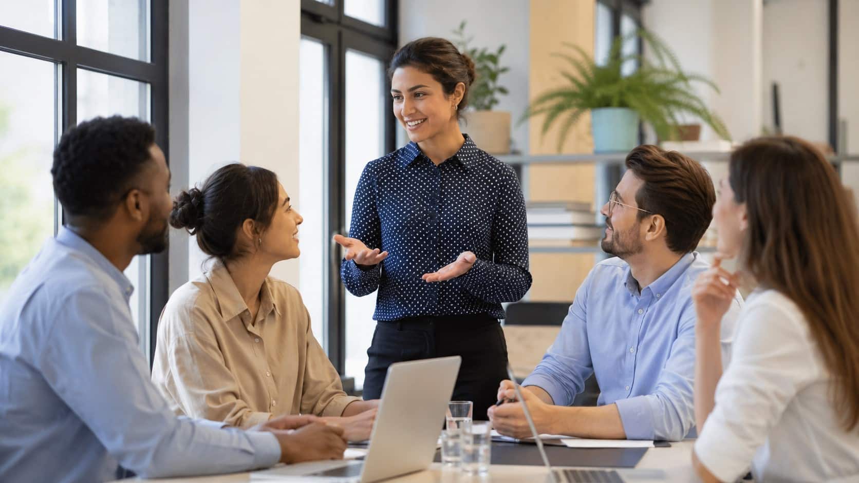 Team collaboration meeting in a modern office discussing strategies to improve internal communications.
