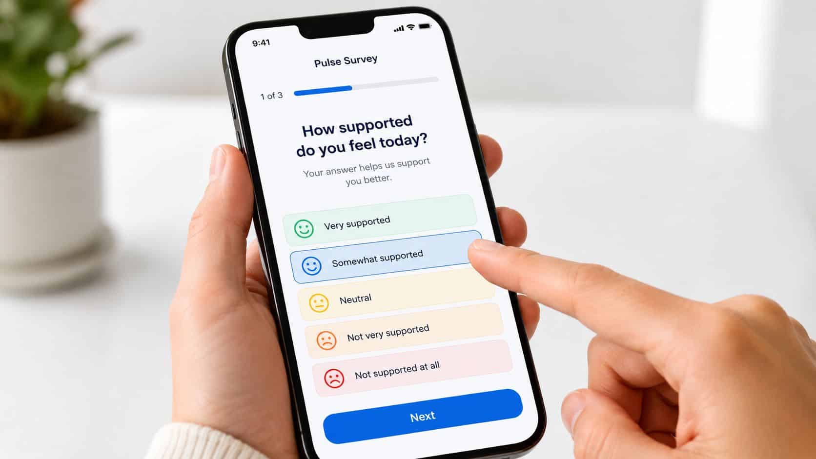 A person using a smartphone to complete an employee pulse survey about feeling supported at work.